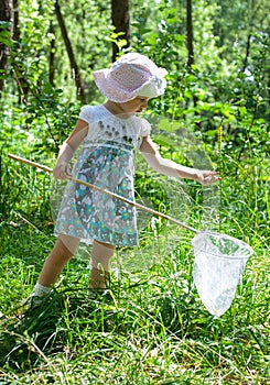Beautiful little girl with butterfly net in a park