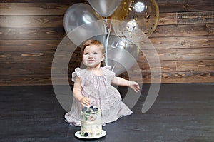 Beautiful little girl celebrating birthday party with balloons and birtday cake.