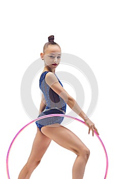 Beautiful little girl child, rhythmic gymnast in blue stage costume standing with hoop against white studio background