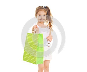 Beautiful little girl child with shopping paper bag on white