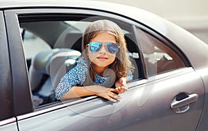 Beautiful little girl child sitting in car, looking out window