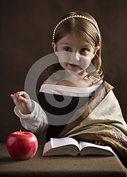 Beautiful little girl Christian, dressed in old clothes, reading the Bible, the hand gestures highlights words and main ideas