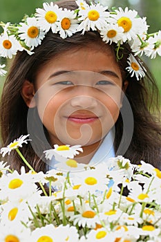 Beautiful little girl with crown of daisies