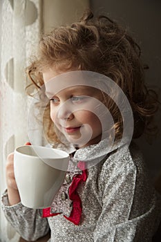 Beautiful little girl with a cup of tea