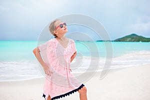 Beautiful little girl in dress at beach having fun. Funny girl enjoy summer vacation.