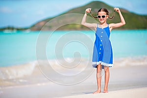 Beautiful little girl in dress at beach having fun. Funny girl enjoy summer vacation.