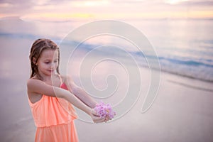 Beautiful little girl in dress at beach having fun. Funny girl enjoy summer vacation.