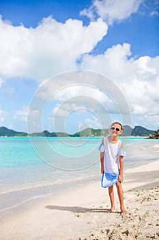 Beautiful little girl in dress at beach having fun. Funny girl enjoy summer vacation.