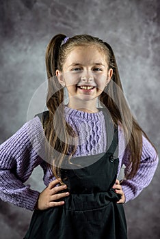 beautiful little girl in dress standing and posing isolated over plain background.