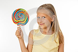 Beautiful little girl eating lollipop on white background