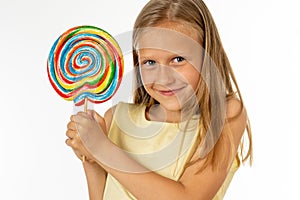 Beautiful little girl eating lollipop on white background
