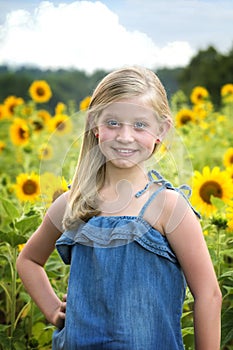 Beautiful little girl in front of sunflower field