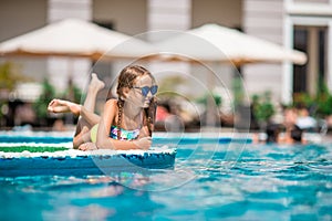 Beautiful little girl having fun near an outdoor pool