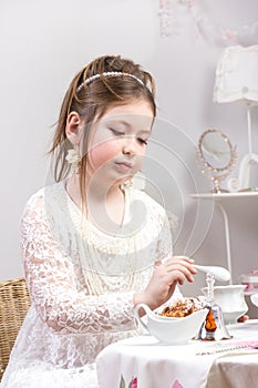 A beautiful little girl having a tea party