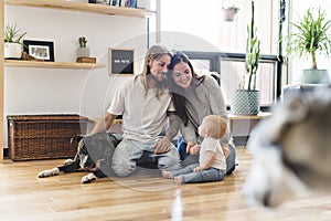 Beautiful little girl and her parent getting some puppy love on the living room