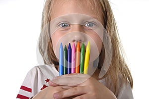 Beautiful little girl holding multicolor crayons set in art school children education concept