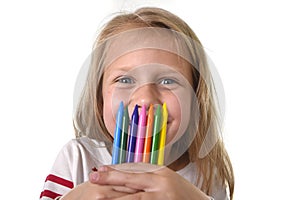 Beautiful little girl holding multicolor crayons set in art school children education concept