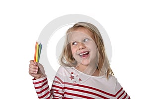 Beautiful little girl holding multicolor crayons set in art school children education concept