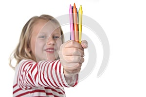 Beautiful little girl holding multicolor crayons set in art school children education concept