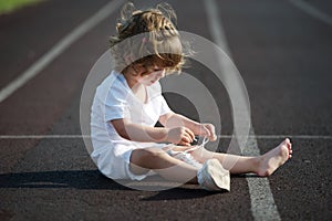 Beautiful little girl learning to tie shoelaces