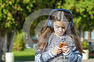 Beautiful little girl listening to music on headphones