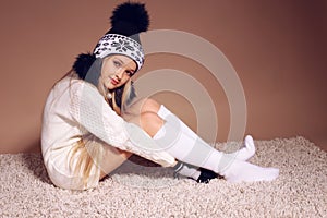 Beautiful little girl with long blond hair in cozy knitted clothes