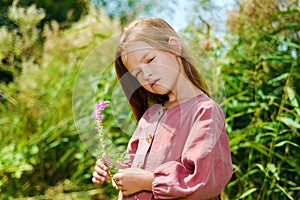 Beautiful little girl looks away dreaming