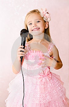 Beautiful little girl with microphone in princess dress