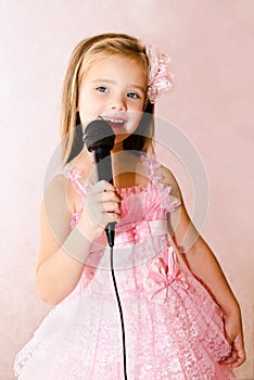 Beautiful little girl with microphone in princess dress