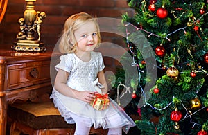 Beautiful little girl near festive christmas tree