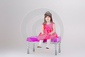 Beautiful little girl in pink Princess dress with crown sitting