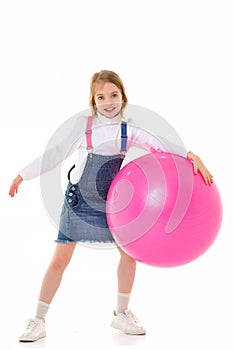 Little girl plays with a big ball for fitness