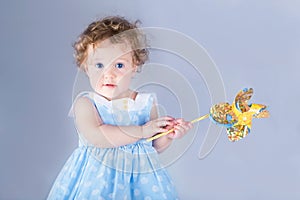 Beautiful little girl playing with a wind toy