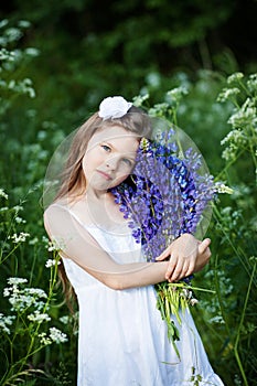 Beautiful little girl with purple lupines