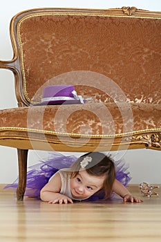 Beautiful little girl in purple skirt lying on
