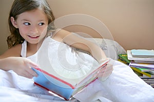 Beautiful little girl reading a book