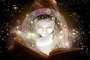 Beautiful little girl reading her magic book