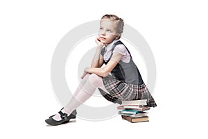 Beautiful little girl in school uniform with books
