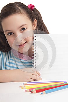 Beautiful little girl showing empty space on notebook photo