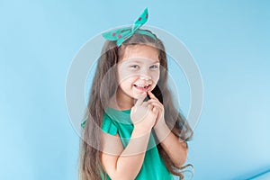 Beautiful little girl shows a fallen tooth