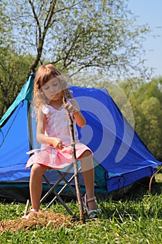 Beautiful little girl sitting near tent photo