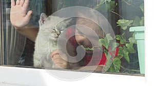 Beautiful little girl smiling and watching out the window. A child looks out the window. Portrait of cheerful kid. self