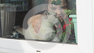 Beautiful little girl smiling and watching out the window. A child looks out the window. Portrait of cheerful kid. self