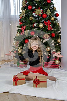 A beautiful little girl stands before the choice of a small or large gift for the New Year and Christmas. The girl