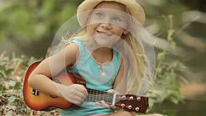 Beautiful little girl in straw hat playing on toy