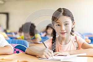 Beautiful little girl  studying in the classroom