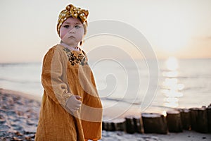 Beautiful little girl on sunset beach