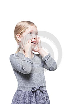 Beautiful little girl surprised looking up on something isolated