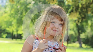 Beautiful little girl taking her sun glasses off and smiling; positive emotions, slow motion