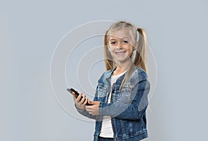 Beautiful Little Girl Using Cell Smart Phone Happy Smiling Wear Jeans Coat Isolated